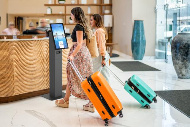 SpacePole Mini Kiosk at a reception desk in a hotel lobby.